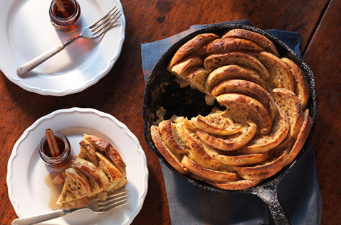 BAYS ARRANGED IN A CAST IRON PAN LIKE A FLOWER WITH A SLICE CUT ON A PLATE NEXT TO IT