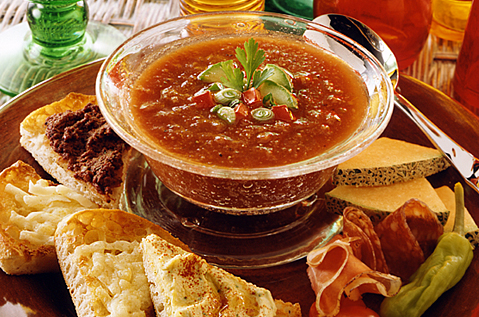 GARNISHED RED SOUP SURROUNDED BY SLICED BAYS