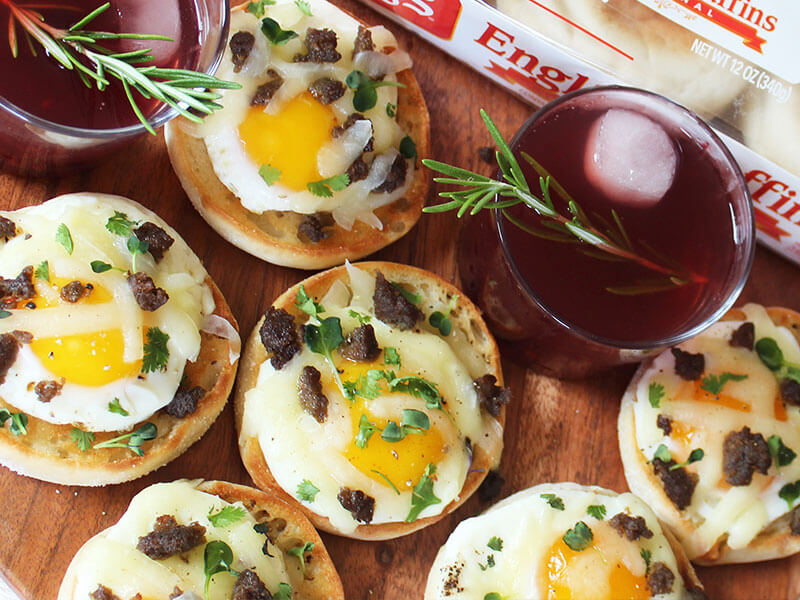 a tray of bays with eggs and meat including two dark purple drinks