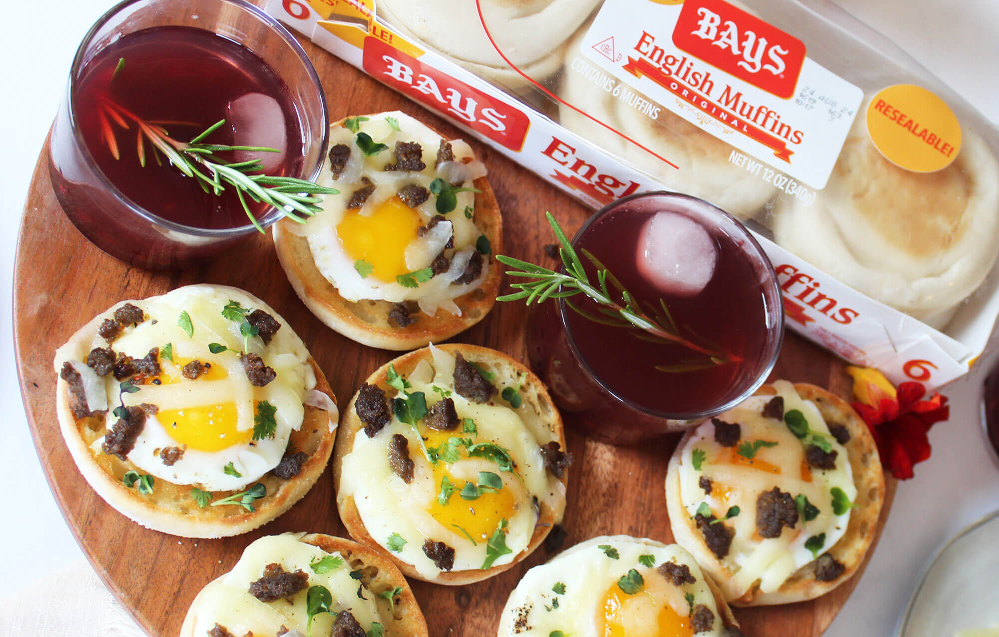 a tray of bays with eggs and meat including two dark purple drinks