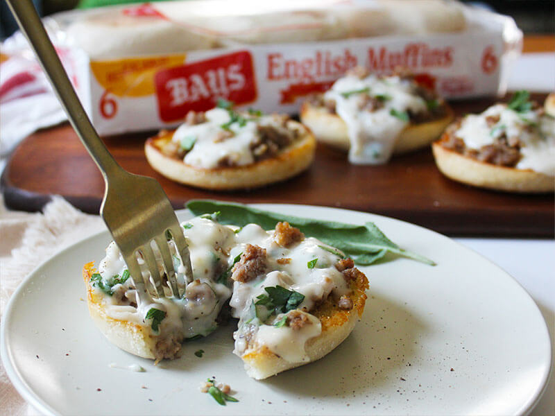 A fork digging into Bays with white sauce and meat on it