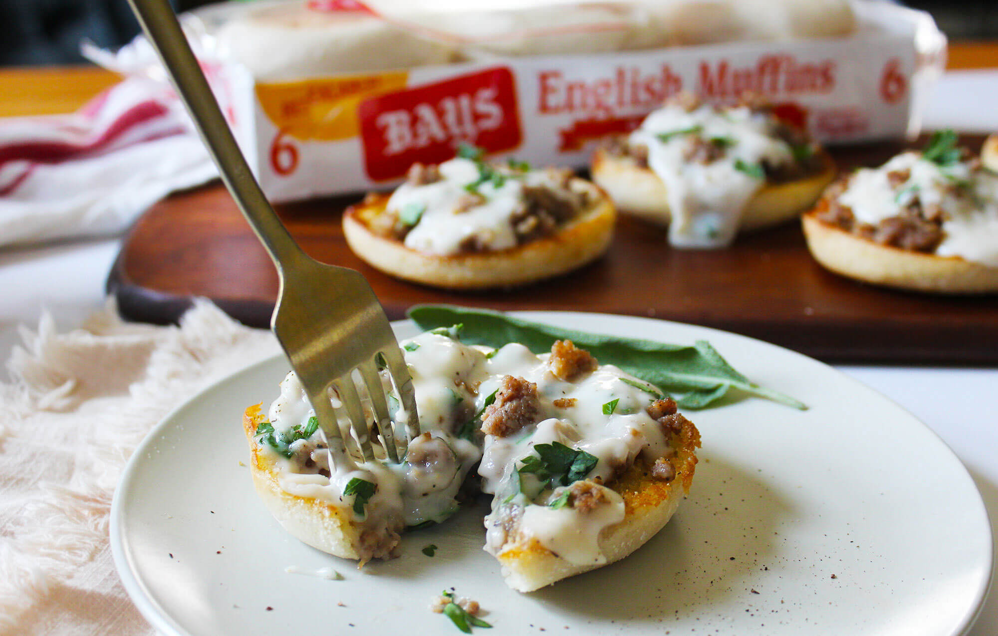 A fork digging into Bays with white sauce and meat on it