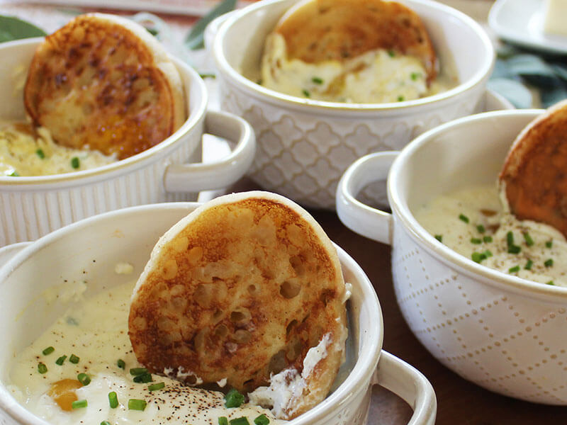 english muffins sitting in four rammekins filled with a creamy dip