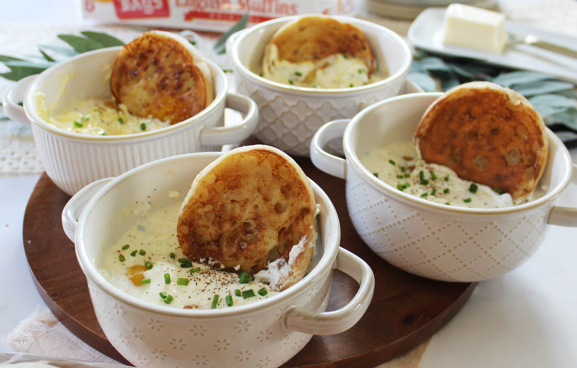 english muffins sitting in four rammekins filled with a creamy dip